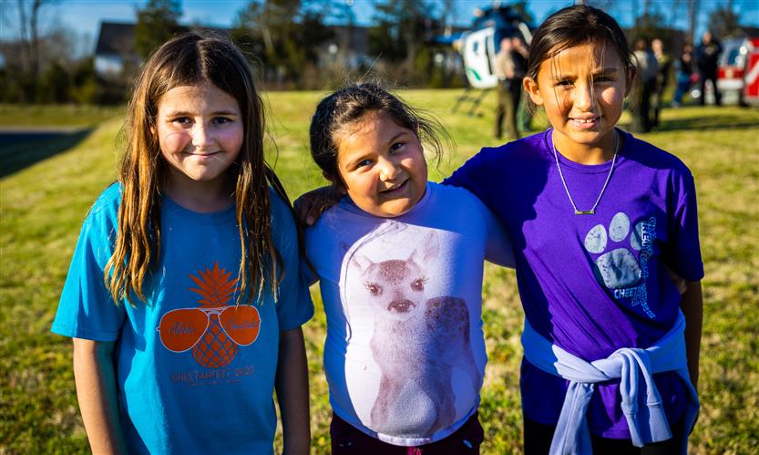 Three girls smile outside